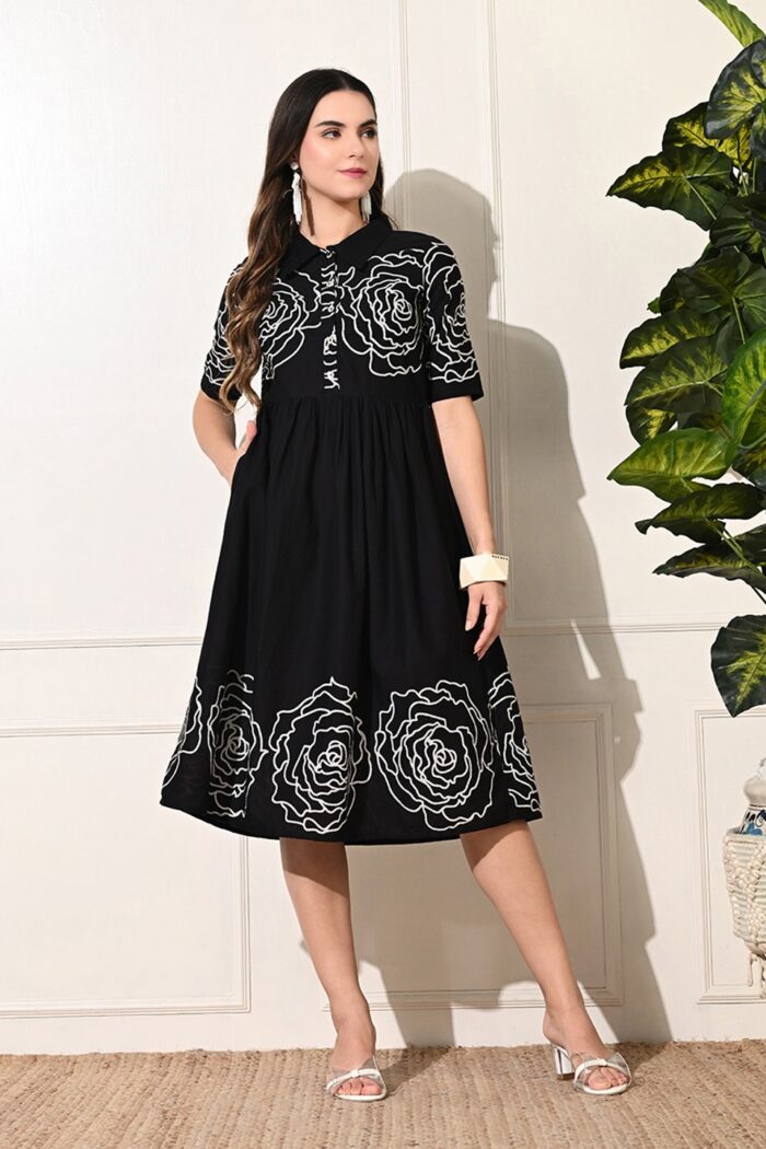 Beautiful black dress with white rose embroidery, combining sophistication and floral charm for a stylish look.